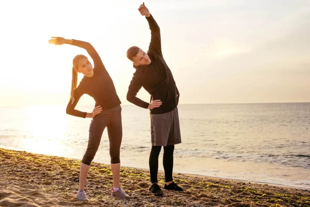 fit young fitness couple working out on beach duri utc
