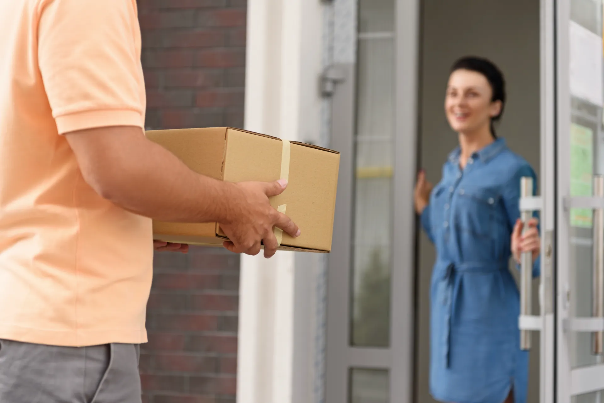 woman receiving package from delivery person at ho utc ()